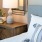 a bed with a lamp and a mirror