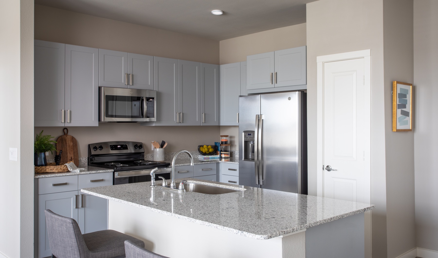 beautifully designed kitchen with granite counters and gray cabinets
