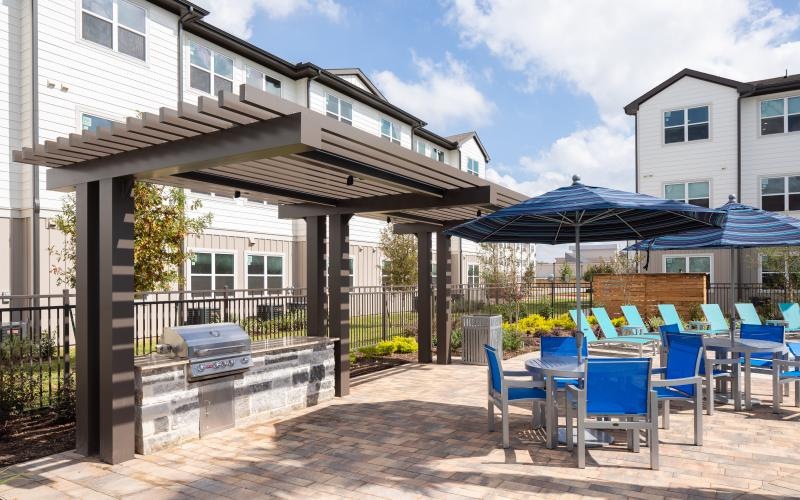 a patio with tables and chairs and umbrellas