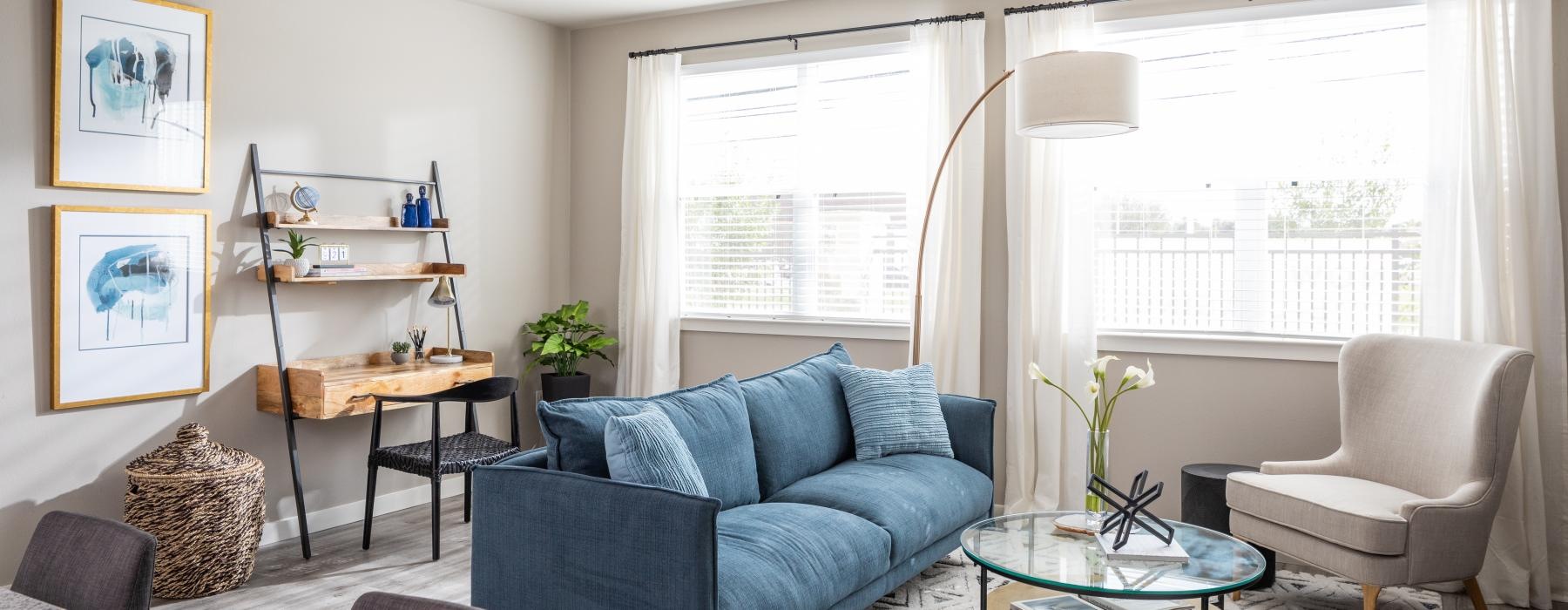 a living room with a blue couch and a table