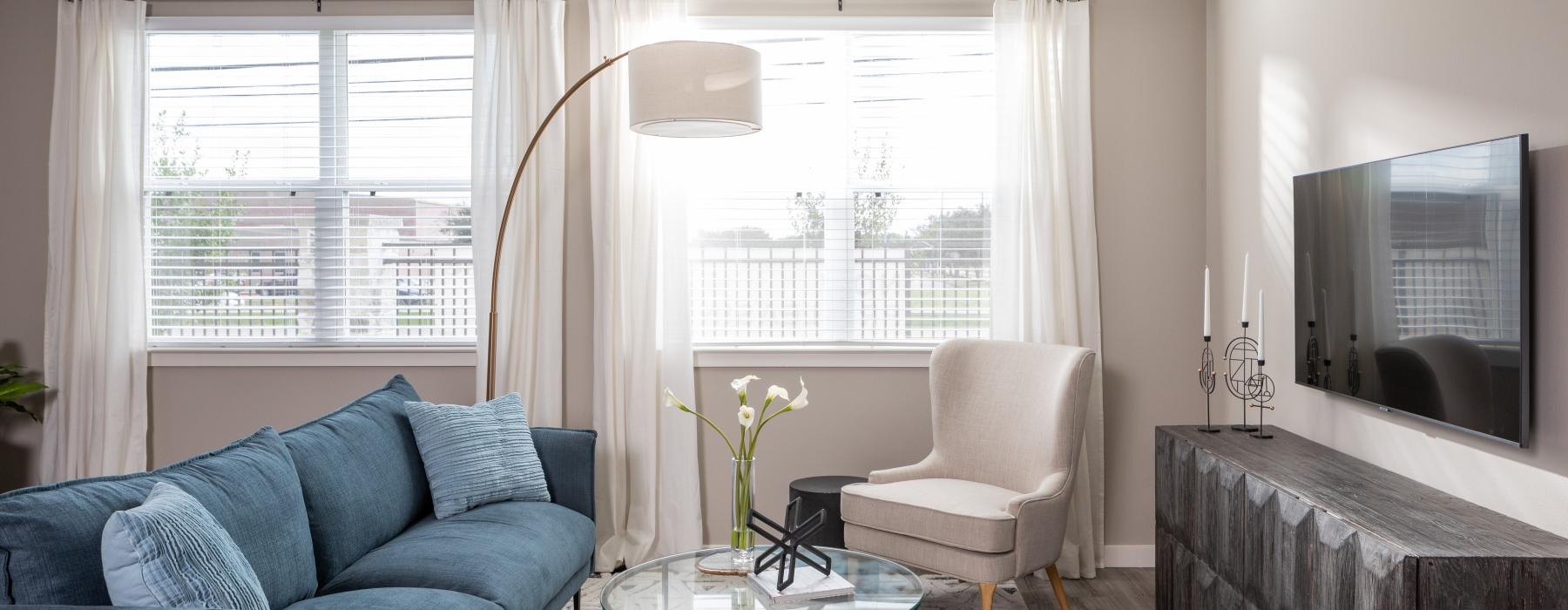 a living room with a blue couch and a television